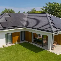 Nowoczesny dom z panelami fotowoltaicznymi na dachu i zadbanym ogrodem.